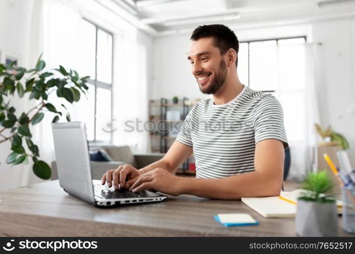 technology, remote job and business concept - man with laptop computer working at home office. man with laptop working at home office