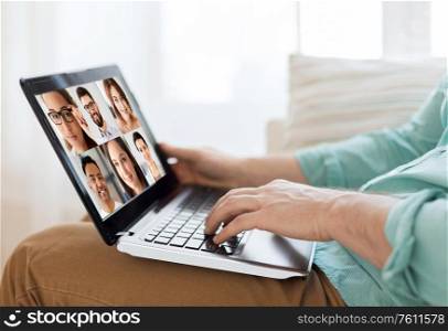 technology, remote job and online communication concept - close up of young man with laptop computer sitting on couch at home and having video call with colleagues. man with laptop having video call with colleagues