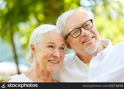 technology, retirement and old people concept - happy senior couple taking selfie and hugging at summer park. happy senior couple taking selfie at summer park