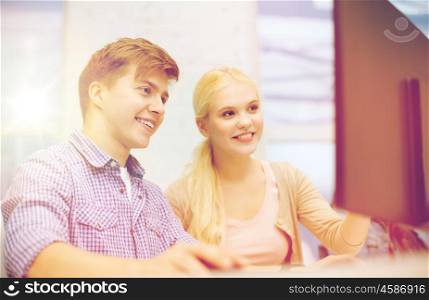 technology, school and education concept - smiling teenage boy and girl in computer class at school