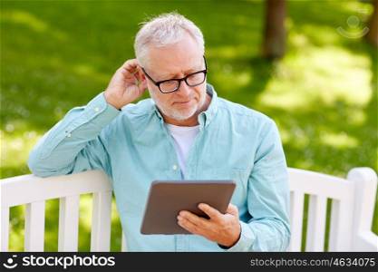 technology, senior people, and lifestyle, distance learning concept - old man with tablet pc computer at summer park