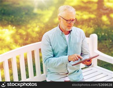 technology, senior people, and lifestyle, distance learning concept - old man with tablet pc computer at summer park. senior man with tablet pc at summer park