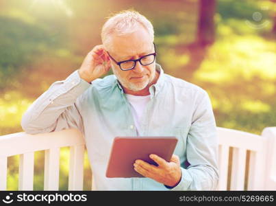 technology, senior people, and lifestyle, distance learning concept - old man with tablet pc computer at summer park. senior man with tablet pc at summer park