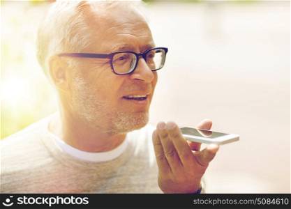 technology, senior people, lifestyle and communication concept - close up of happy old man using voice command recorder or calling on smartphone outdoors. old man using voice command recorder on smartphone. old man using voice command recorder on smartphone