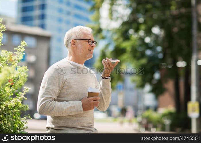 technology, senior people, lifestyle and communication concept - happy old man using voice command recorder or calling on smartphone outdoors