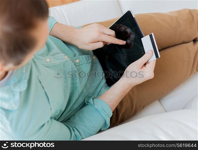technology, shopping, banking, leisure and lifestyle concept - close up of man with laptop computer and credit card at home
