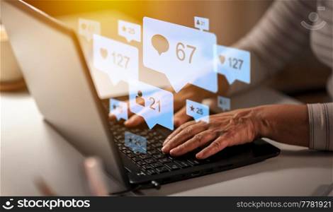 technology, social media and people concept - close up of senior woman hands typing on laptop at home with virtual icons. hands of old woman with laptop and internet icons