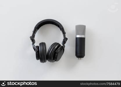 technology, sound recording and audio equipment concept - headphones and microphone on white background. headphones and microphone on white background