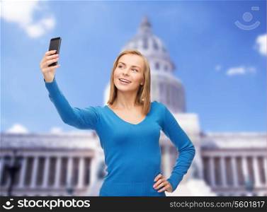 technology, travel and internet concept - smiling woman taking self picture with smartphone camera