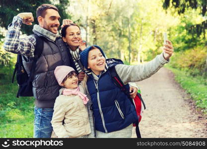 technology, travel, tourism, hike and people concept - happy family with backpacks taking selfie by smartphone and hiking. family with backpacks taking selfie by smartphone. family with backpacks taking selfie by smartphone