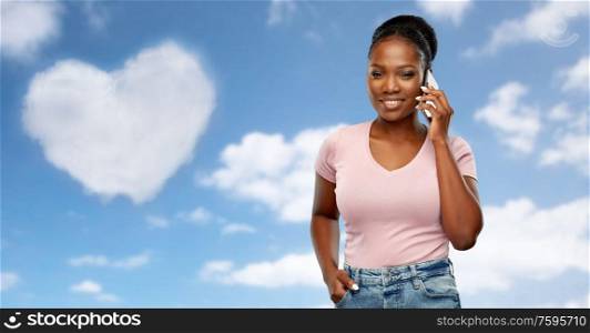 technology, valentines day and love concept - happy african american woman calling on smartphone over grey background. happy african american woman calling on smartphone
