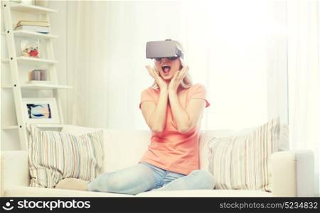 technology, virtual reality, cyberspace, entertainment and people concept - happy amazed young woman with virtual reality headset or 3d glasses sitting on sofa at home. woman in virtual reality headset or 3d glasses