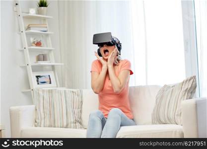 technology, virtual reality, cyberspace, entertainment and people concept - happy amazed young woman in virtual reality headset or 3d glasses and headphones sitting on sofa at home