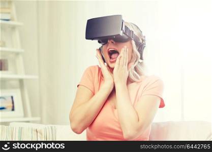 technology, virtual reality, cyberspace, entertainment and people concept - happy amazed young woman in virtual reality headset or 3d glasses and headphones at home. woman in virtual reality headset or 3d glasses