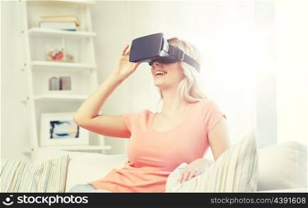 technology, virtual reality, cyberspace, entertainment and people concept - happy young woman with virtual reality headset or 3d glasses sitting on sofa at home. woman in virtual reality headset or 3d glasses. woman in virtual reality headset or 3d glasses
