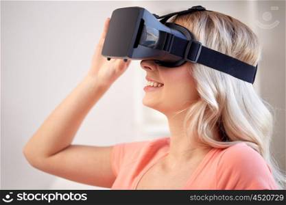 technology, virtual reality, cyberspace, entertainment and people concept - happy young woman with virtual reality headset or 3d glasses at home