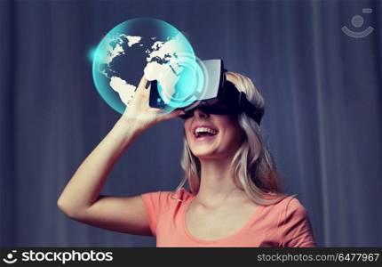 technology, virtual reality, cyberspace, entertainment and people concept - happy young woman with virtual reality headset or 3d glasses at home looking at world globe projection. woman in virtual reality headset or 3d glasses. woman in virtual reality headset or 3d glasses