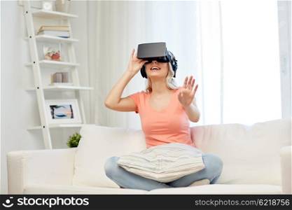 technology, virtual reality, entertainment and people concept - happy young woman in virtual reality headset or 3d glasses and headphones playing game at home and touching something invisible