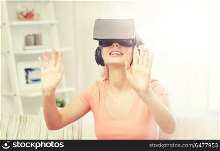 technology, virtual reality, entertainment and people concept - happy young woman in virtual reality headset or 3d glasses and headphones playing game at home and touching something invisible. woman in virtual reality headset or 3d glasses. woman in virtual reality headset or 3d glasses