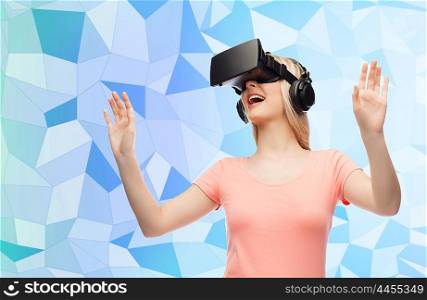 technology, virtual reality, entertainment and people concept - happy young woman with virtual reality headset or 3d glasses and headphones playing game over blue low poly texture background