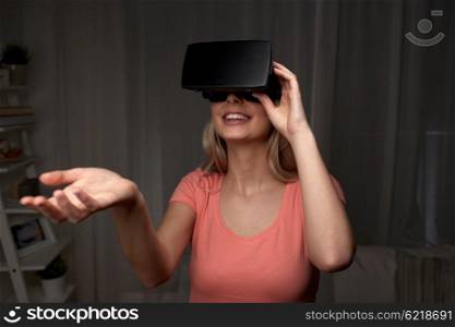 technology, virtual reality, entertainment and people concept - happy young woman with virtual reality headset or 3d glasses playing game at home and holding something invisible