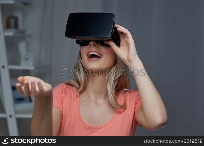 technology, virtual reality, entertainment and people concept - happy young woman with virtual reality headset or 3d glasses playing game at home and holding something invisible