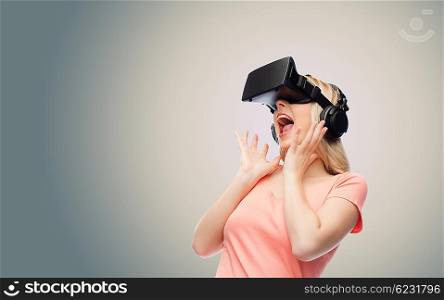 technology, virtual reality, entertainment and people concept - happy young woman with virtual reality headset or 3d glasses and headphones over gray background