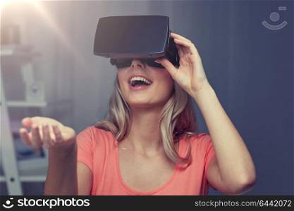 technology, virtual reality, entertainment and people concept - happy young woman with virtual reality headset or 3d glasses playing game at home and holding something invisible. woman in virtual reality headset or 3d glasses