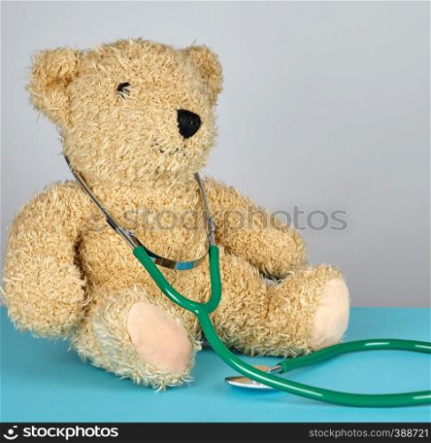 teddy bear and green medical stethoscope, pediatrics concept