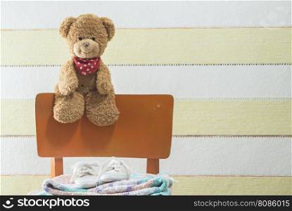 Teddy bear in a baby room on chair
