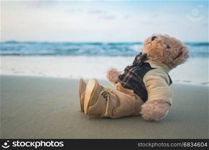 Teddy bear sitting on the sand beach