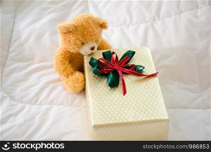 Teddy bear.Teddy Bear sitting on the bed with gift box