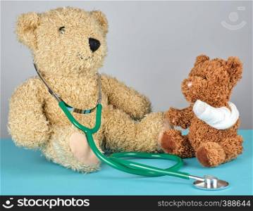 teddy bear with bandaged paw and stethoscope, pediatrics concept
