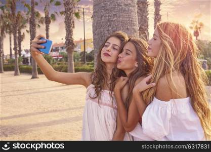 Teen best friends girls group shooting selfie photo smartphone in palm trees beach filtered image