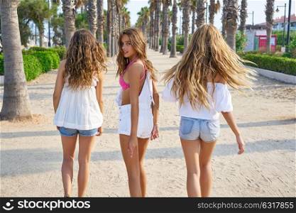 Teen best friends girls group walking happy in a palm trees beach area