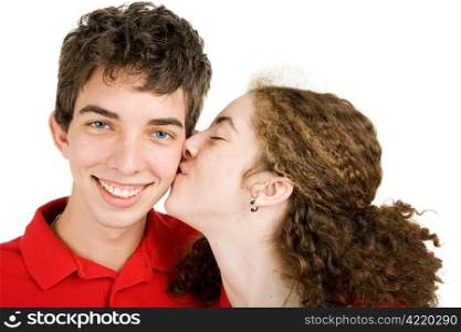 Teen boy getting a kiss on the cheek from his girlfriend. Isolated on white.