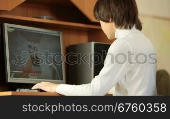 Teen Boy Playing Desktop Computer Games At Home