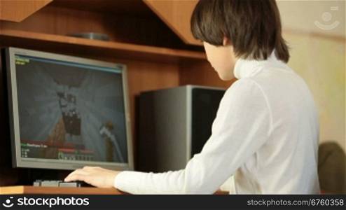 Teen Boy Playing Desktop Computer Games At Home