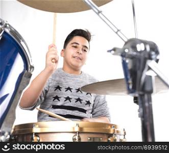 teen boy plays the drums in studio against white background