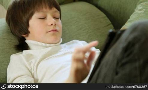 Teen Boy Using a Touch Screen Tablet PC At Home