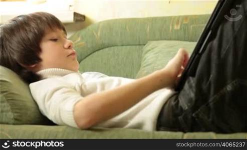 Teen Boy Using a Touch Screen Tablet PC At Home, Side View