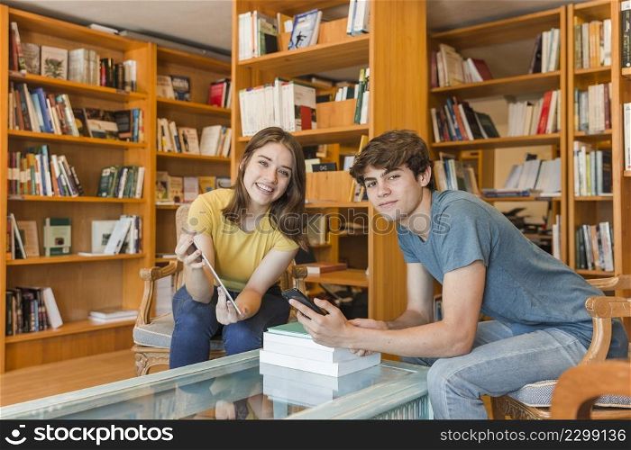 teen couple with gadgets library