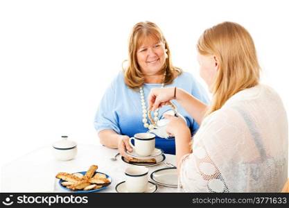 Teen daughter pouring tea for her mother at their tea party. Isolated on white.