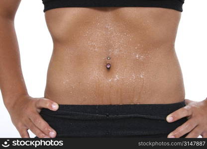 Teen girl&acute;s abdomen with belly ring covered in sweat.