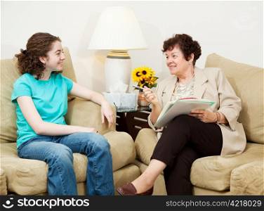 Teen girl being interviewed by a mature woman. Could be college or job interview, or counseling session.