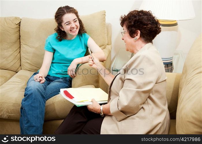 Teen girl being interviewed by a middle aged woman. Could be counselor or job application.