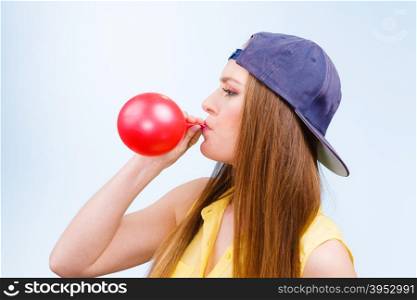 Teen girl blowing red balloon.. Teens and parties. Preparation for celebration. Trendy teenage girl blowing red balloon. Young beauty woman prepare accessories for party.