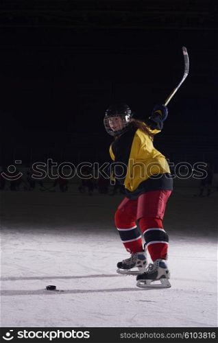 teen girl children ice hockey player in action kicking puck with stick