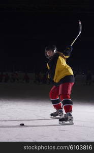 teen girl children ice hockey player in action kicking puck with stick