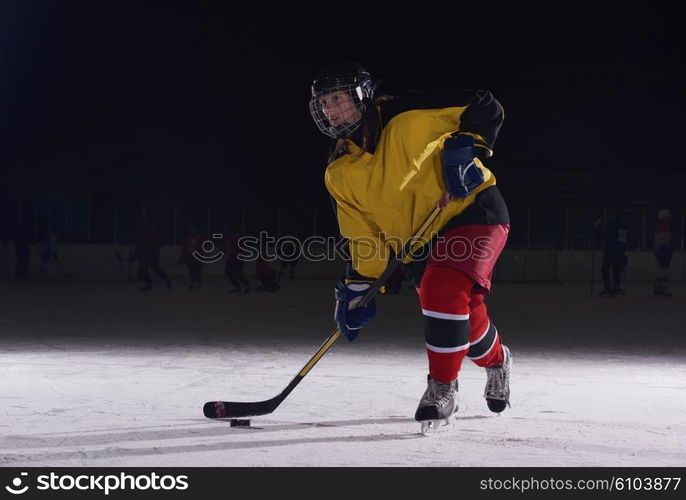 teen girl children ice hockey player in action kicking puck with stick